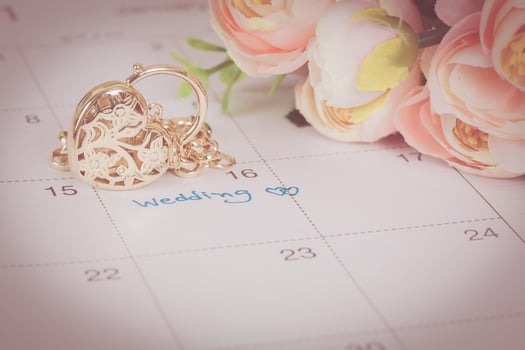 word wedding on calendar and gold bracelet with heart photo