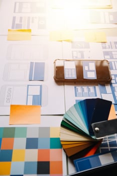 Close up ux developer and ui designer brainstorming about mobile app interface wireframe design on table with customer breif and color code at modern office.Creative digital development agency photo