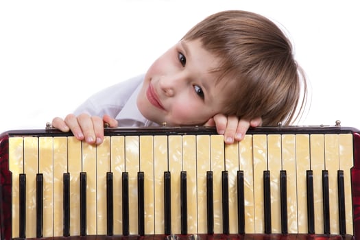 Child with a musical instrument. Elementary age boy with an accordion. photo