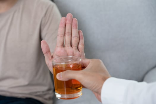 man refuses say no and avoid to drink an alcohol whiskey , stopping hand sign male, alcoholism treatment, alcohol addiction, quit booze, Stop Drinking Alcohol. Refuse Glass liquor, unhealthy, reject photo