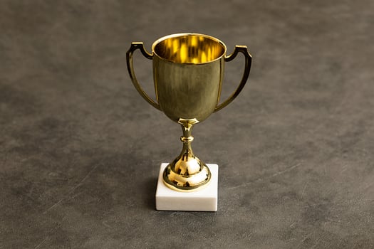 Simply design winner or champion gold trophy cup on concrete stone grey background. Victory first place of competition. Winning or success concept. Top view copy space. photo