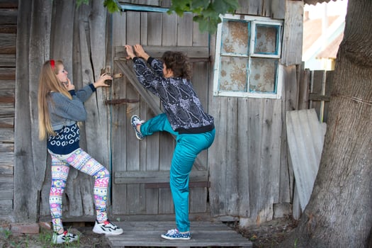 Two funny country girls break down the door in the old house. Russian girls in the nineties of the last century. photo