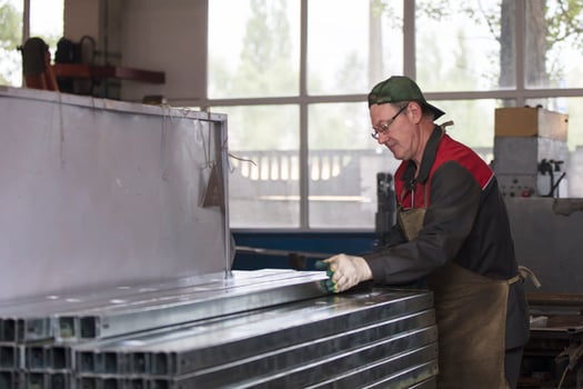 Worker in a workshop with metal ventilation pipes. photo