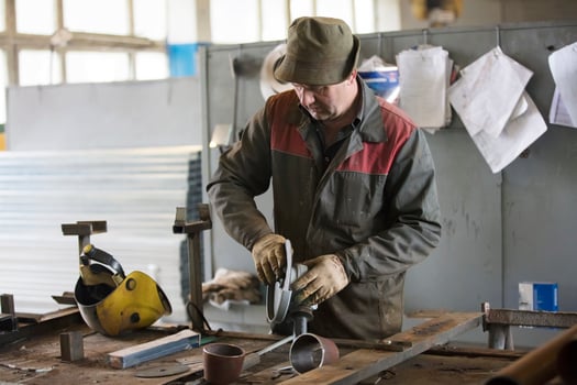 Worker in a workshop with a grinder. photo