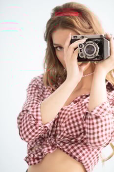 Beautiful girl photographer with a vintage photo camera.
