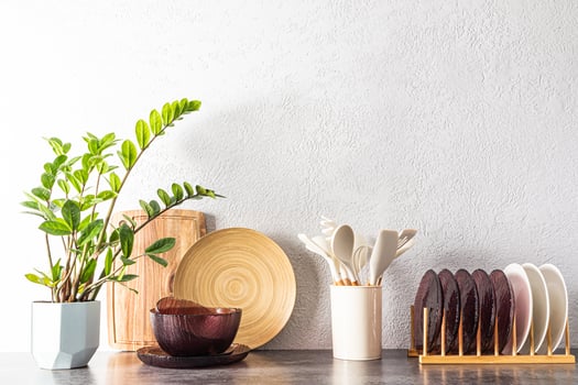 various kitchen environmentally friendly utensils made of wood and glass on the kitchen countertop. interior of a modern kitchen. indoor flower photo