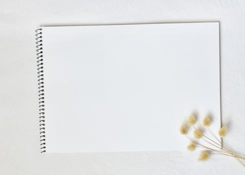 white watercolor sketchbook on linen tablecloth with sprigs of lagurus photo
