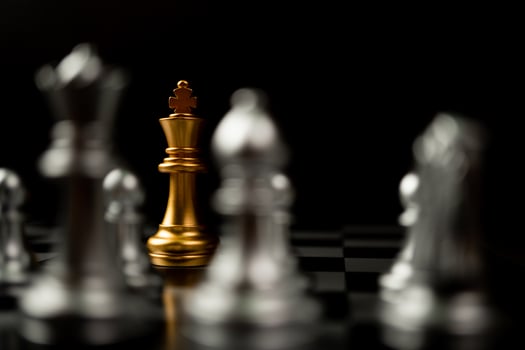 Golden King chess standing in front of other chess, Concept of a leader must have courage and challenge in the competition, leadership and business vision for a win in business games photo