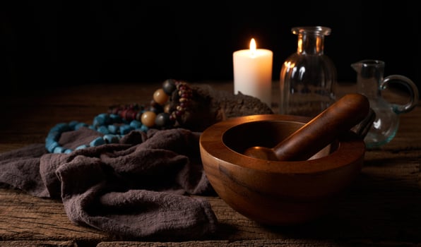 concept of magic potion n a wooden table and white candle with a mortar on dark background. macabre, witchcraft photo
