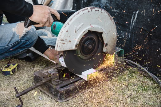 Man doing metal work using hand cutting machine tool photo