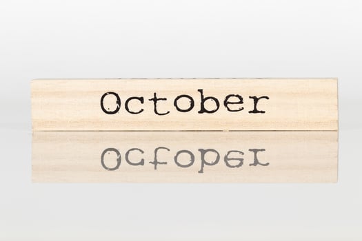wooden cube with an inscription October on a white background photo