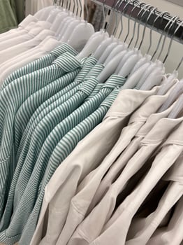 Clothes on a hanger in a store. Assortment in the shop window. Shopping summer female. photo