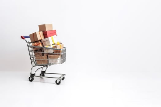 a shopping cart filled with boxes on top and around isolated on white background with copy space. photo