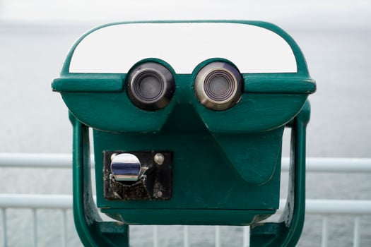 Green Tourist Binocular on Coins and Defocused Sea on Second Plan photo