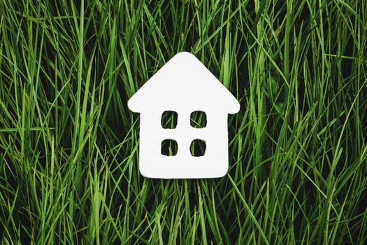 White paper house on green grass, sustainable living and eco-friendly housing photo