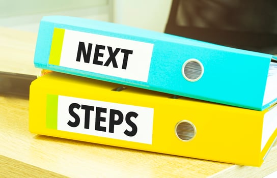 Two office folders with text next steps photo