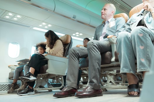 Passengers listen to flight attendants demonstrate how to use safety equipment. photo