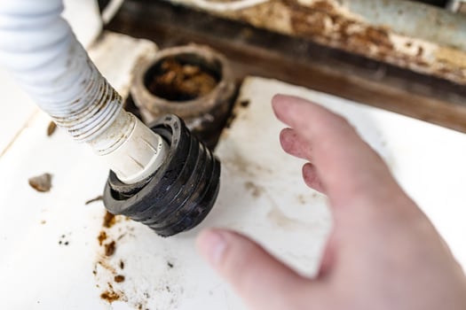 hand of plumber near corrugated drain hose closeup photo