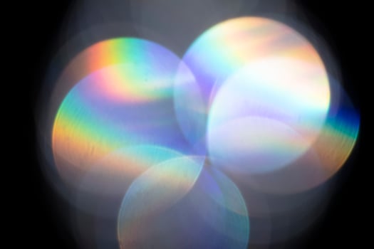 Lens flare, Bokeh lights. Reflections from glass, diamond, crystal. Defocused shining colorful rainbow light leaks, rays on black background photo