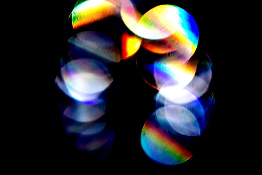 Lens flare, Bokeh lights. Reflections from glass, diamond, crystal. Defocused shining colorful rainbow light leaks, rays on black background photo