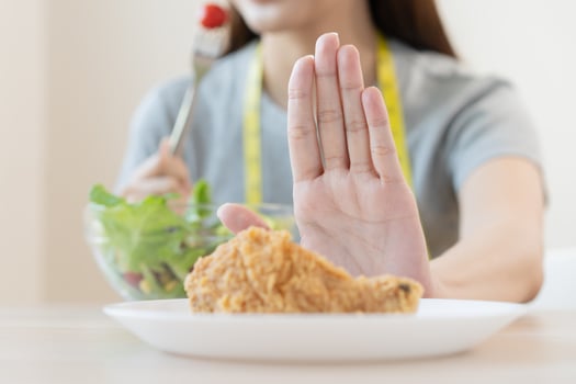 Diet, Dieting asian young woman or girl push out, deny fried chicken, junk food and choose fresh vegetables salad of bowl, eat food for good healthy, health when hungry. Female weight loss people photo