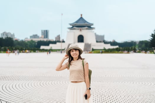 woman traveler visiting in Taiwan, Tourist with hat sightseeing in National Chiang Kai shek Memorial or Hall Freedom Square, Taipei City. landmark and popular attractions. Asia Travel concept photo