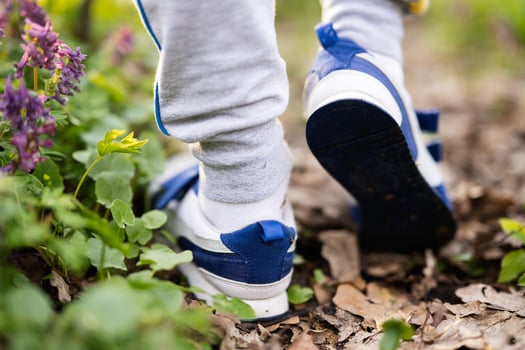 Boy legs wear sneakers walking on forest trail. Outdoor spring leisure concept. photo