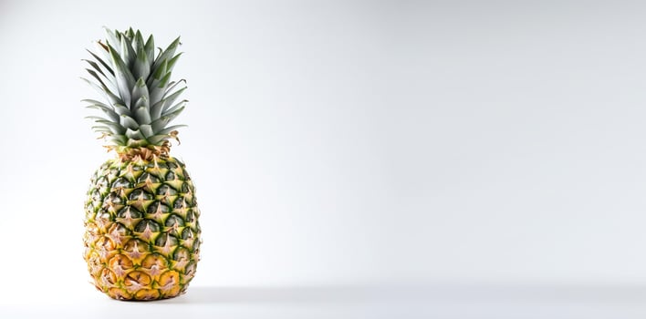 Isolated ripe fresh pineapple with leaf on white background. Vitamin-rich fruit. . photo