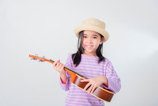 Cute little girl in swimsuit playing ukulele. Happy vacation concept. photo