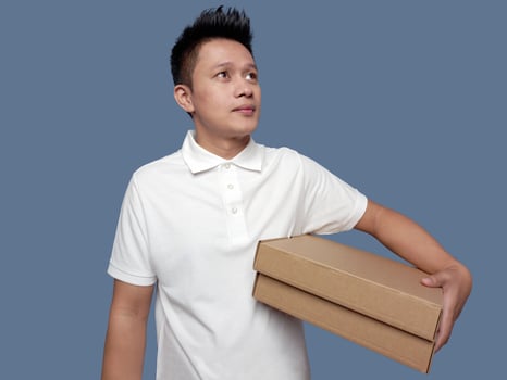 Man holding cardboard box and looking up photo
