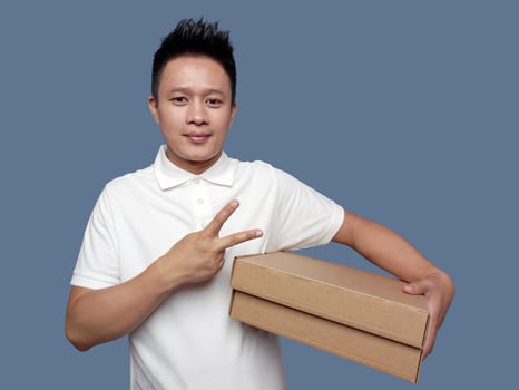 Man holding cardboard box with two finger gesture photo