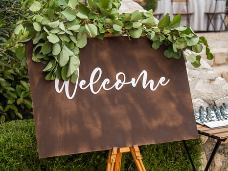 Plaque with inscription greeting guests at wedding. Welcome inscription sign wedding decorations. Wedding decor outdoor marriage photo