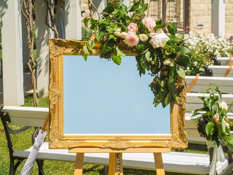 Wedding decorations. Plate with fresh flowers for of events inscription. Board for information and congratulations at ceremony and event photo