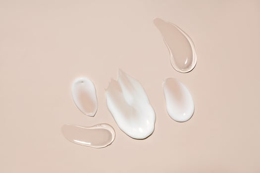 cosmetic smears of creamy and gel texture on a pastel beige background, top view photo