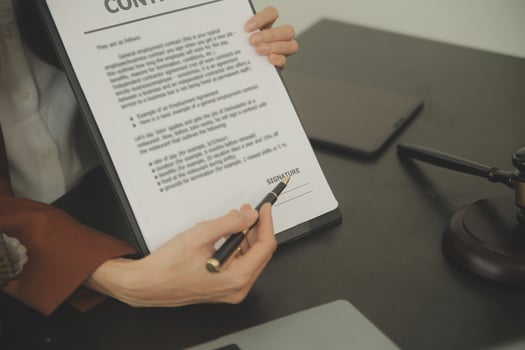 Justice and Law concept. Legal counsel presents to the client a signed contract with gavel and legal law or legal having team meeting at law firm in background photo