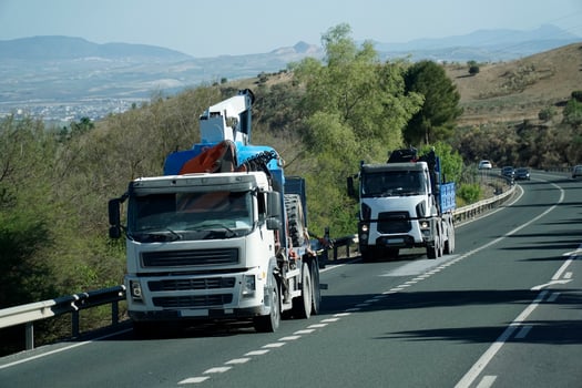 Two Trucks With Construction Equipment on a Road - Front View photo