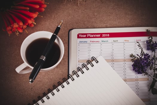 personal organizer or planner with fountain pen and hot coffee on wood table. photo