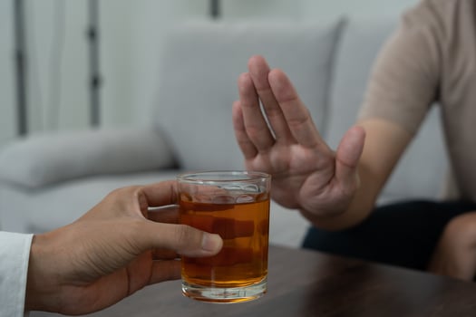 man refuses say no and avoid to drink an alcohol whiskey , stopping hand sign male, alcoholism treatment, alcohol addiction, quit booze, Stop Drinking Alcohol. Refuse Glass liquor, unhealthy, reject photo