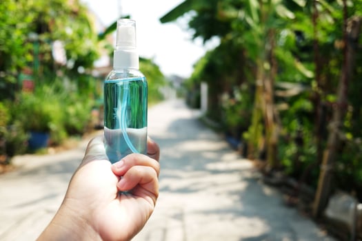 Hand holding a bottle of Ethanol or ethyl alcohol spray for based hand rub is highly effective in reducing influenza a virus on human hands in natural garden. Healthy and Covid19 epidemic Concept. photo