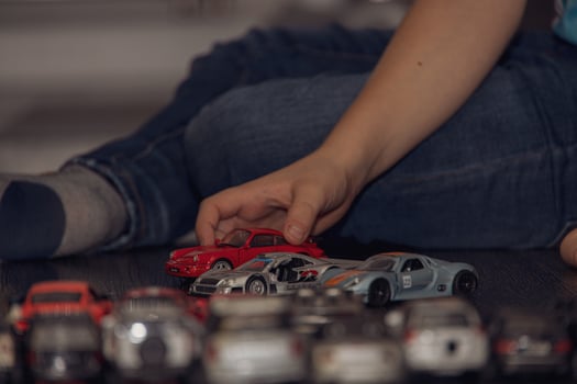 colorful toy cars arranged in a row on the floor during a child's play photo