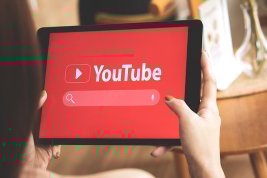 April 14, 2023 in Bangkok, Thailand. Woman holds iPad to search video content on YouTube app at Cafe shop in holidays. ideas for creatives Planning on uploading videos, and update news photo