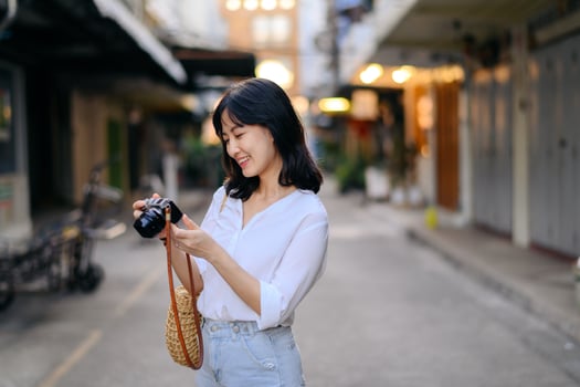 Portrait of asian woman traveler using camera at street of Bangkok, Thailand. Asia summer tourism vacation concept photo