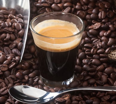 Espresso coffee in glass cup with coffee beans. photo