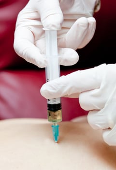 A person getting an injection into their arm photo
