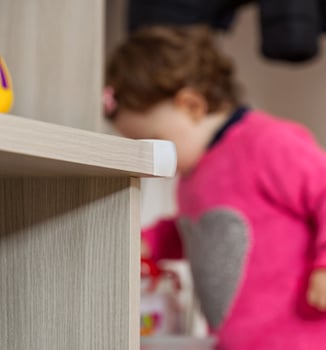 A child in a pink sweater is looking at a toy photo