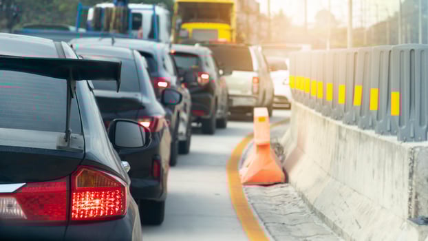 Abstract to blurred of cars on the cement road. Cars parked in a long queue during rush hour. Curved concrete road path with road guards on the sides. photo