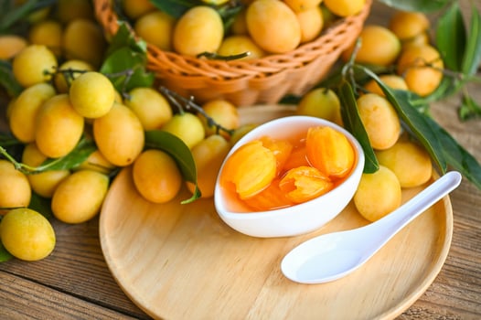 tropical fruit Name in Thailand sweet Yellow Marian Plum Maprang Plango or Mayong chid, Sweet dessert marian plum fruit  on bowl for food and wooden background photo