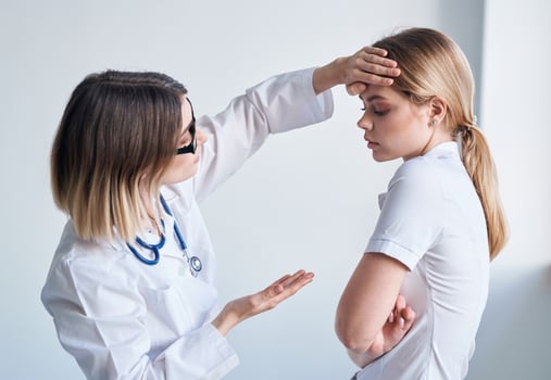 Doctor in a medical gown measure the temperature of a female patient providing medicine services photo
