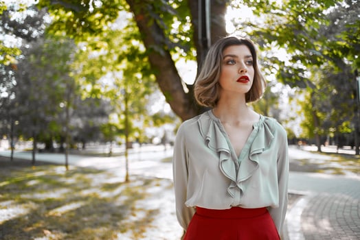 woman in red skirt walks in the park trees lifestyle photo