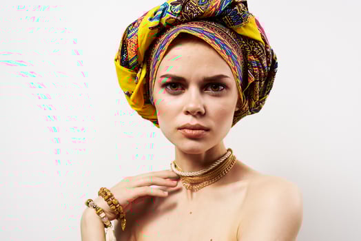 pretty woman holding her head decoration multicolored turban fashion light background photo